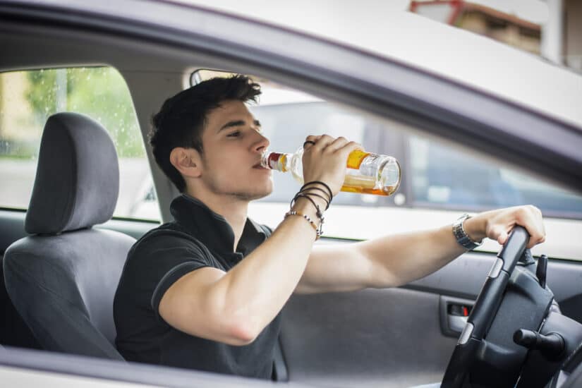Young,Handsome,Man,Driving,His,Car,While,Drinking,Alcohol,In