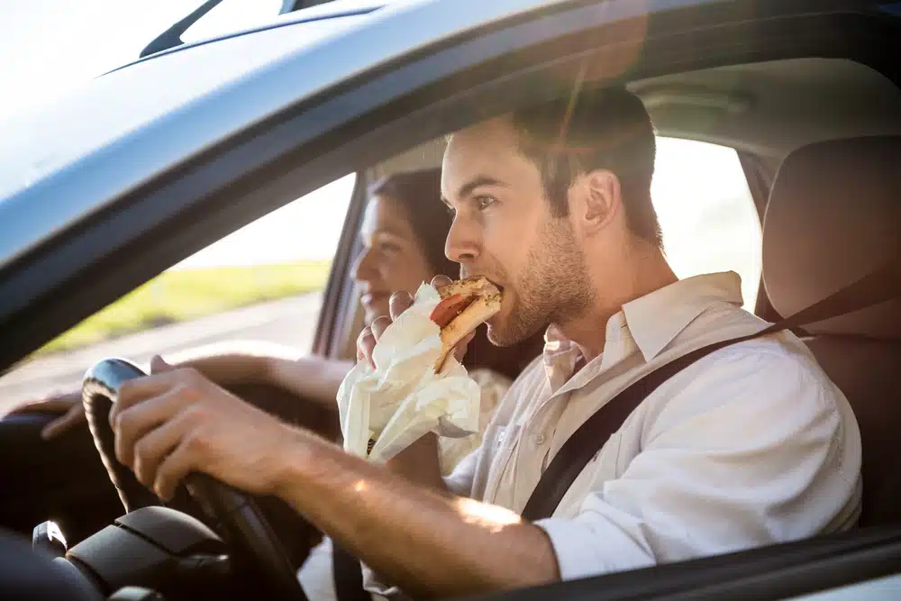 Couple,In,Car, ,Man,Is,Driving,And,Eating,Baguette