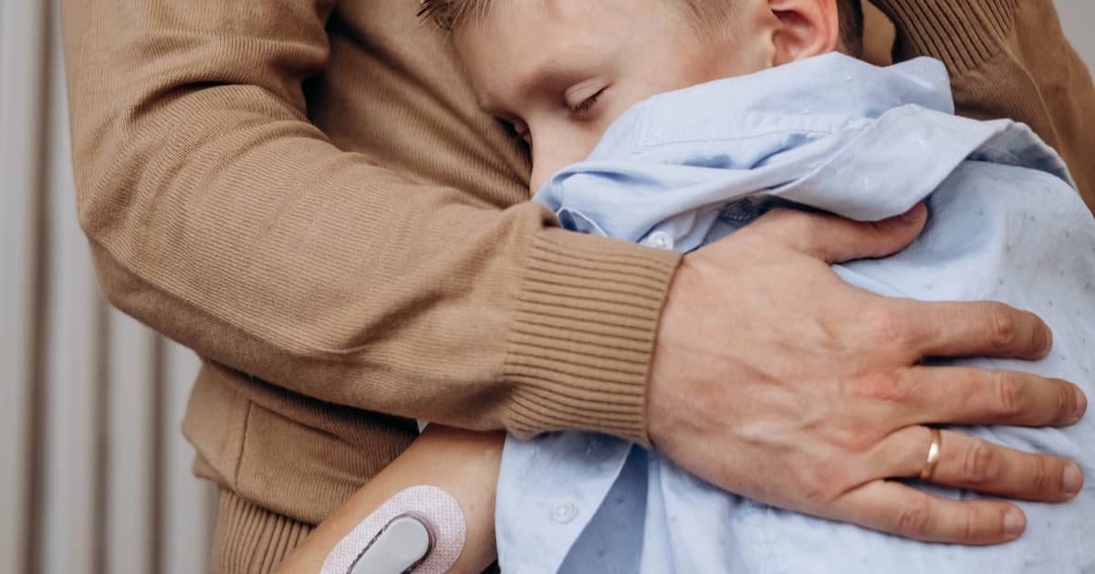 Child with diabetes hugs parent. | Bernheim Kelley Injury Lawyers