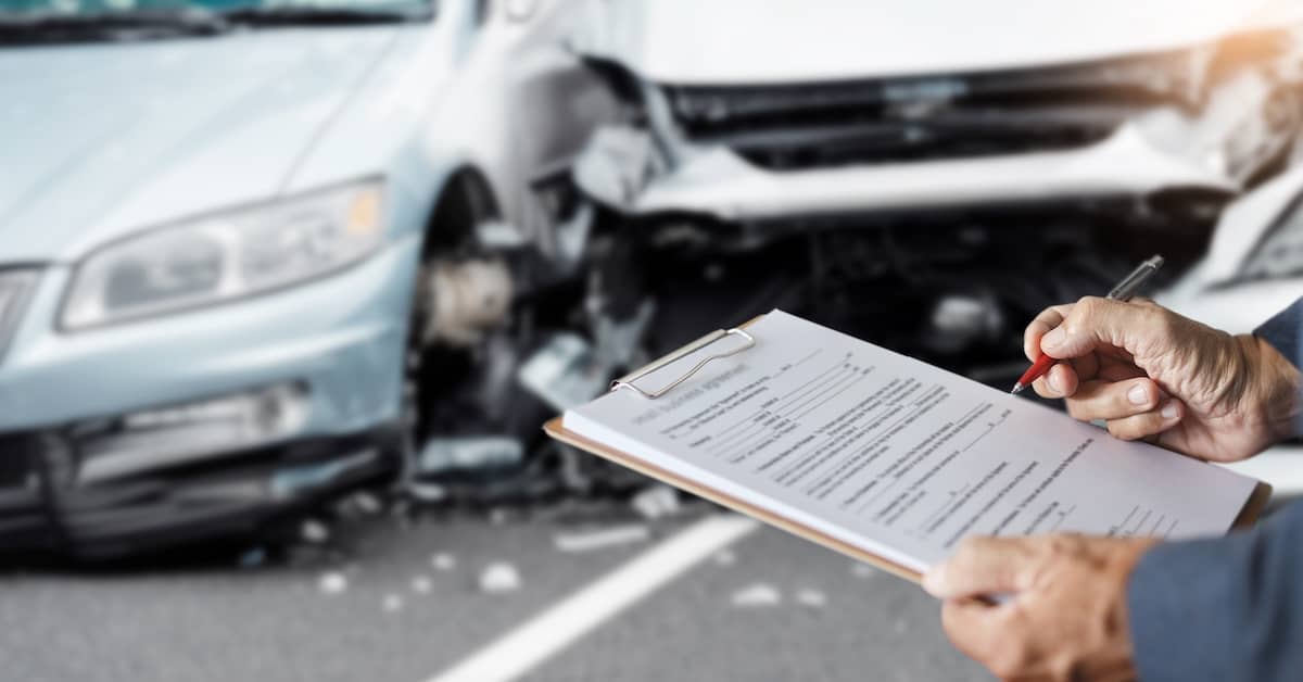 Person writing crash report and car accident. | Bernheim Kelley Injury Lawyers