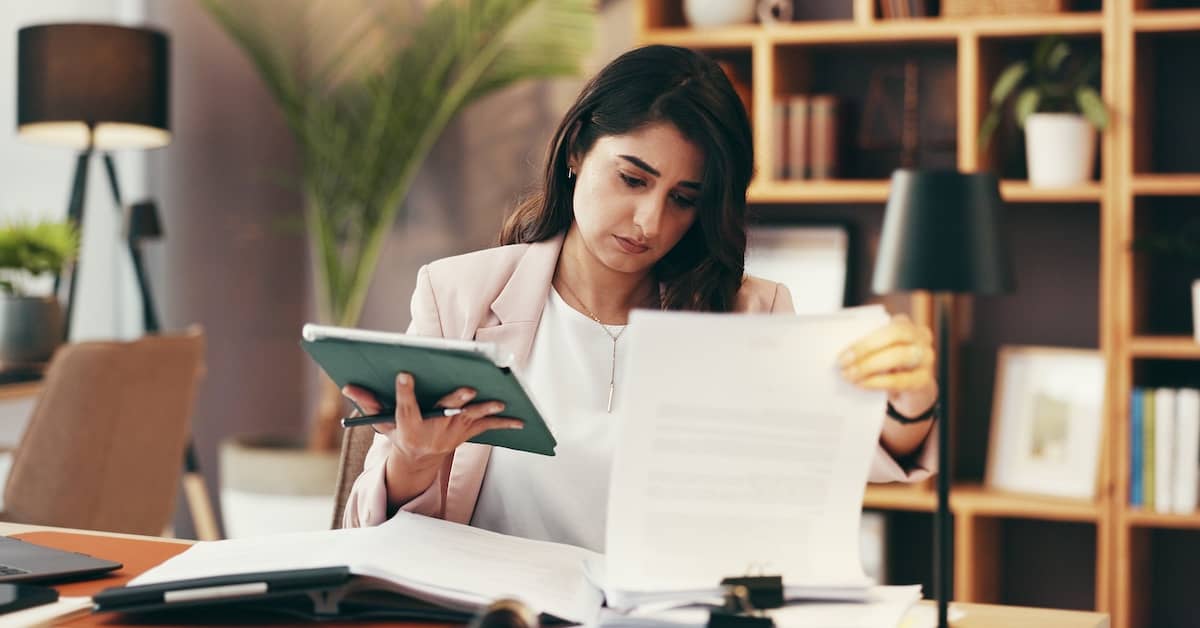 Personal injury lawyer looking at papers and iPad. | Bernheim Kelley Injury Lawyers