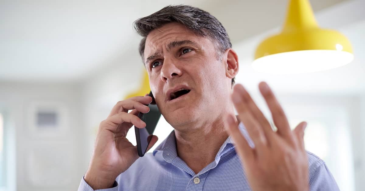 Man on phone with solar company telemarketer. | Bernheim Kelley